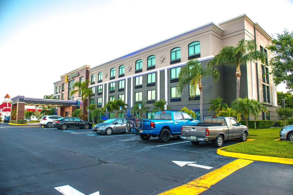 un estacionamiento con autos estacionados frente a un edificio en La Quinta by Wyndham Clearwater South en Clearwater