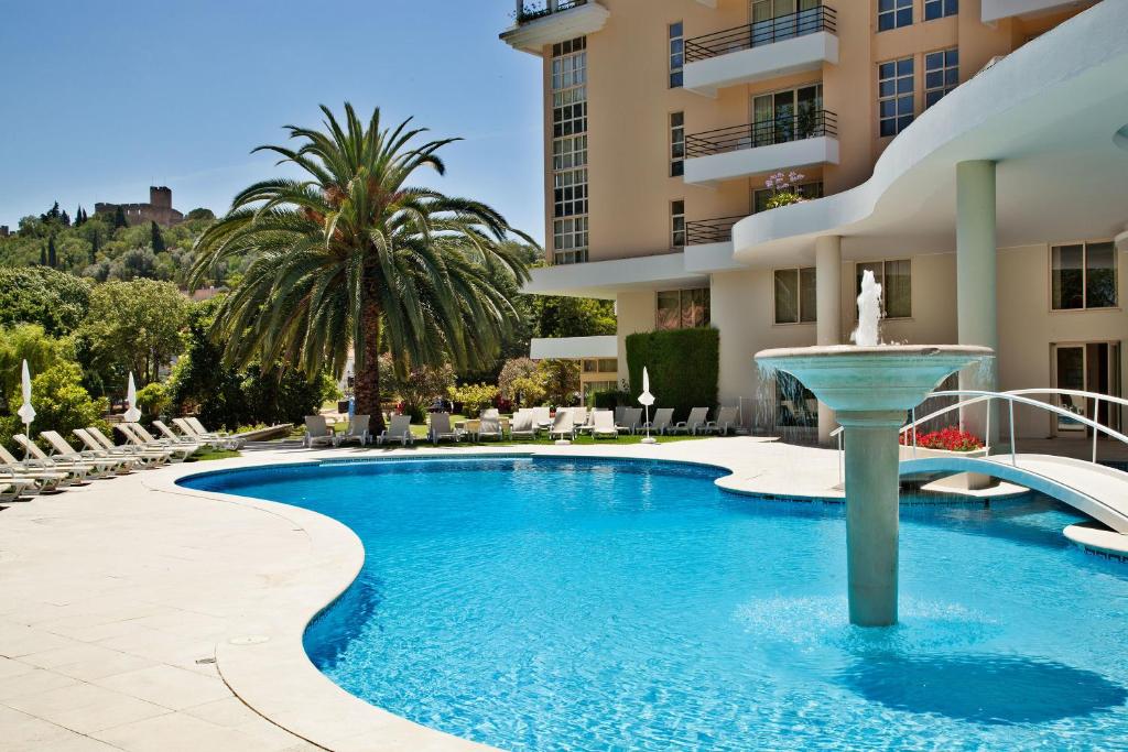 una piscina con una fuente frente a un edificio en Hotel Dos Templarios, en Tomar