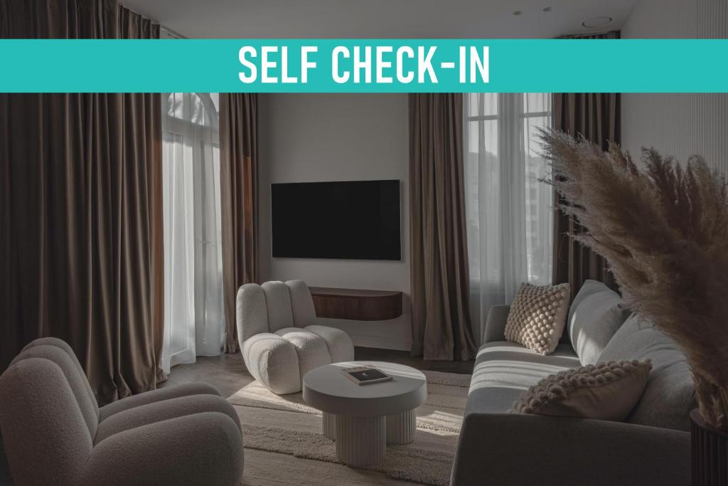 d'un salon avec un mobilier blanc et une télévision. dans l'établissement Modern 1 Bedroom Apartment next to Monte Carlo, à Beausoleil