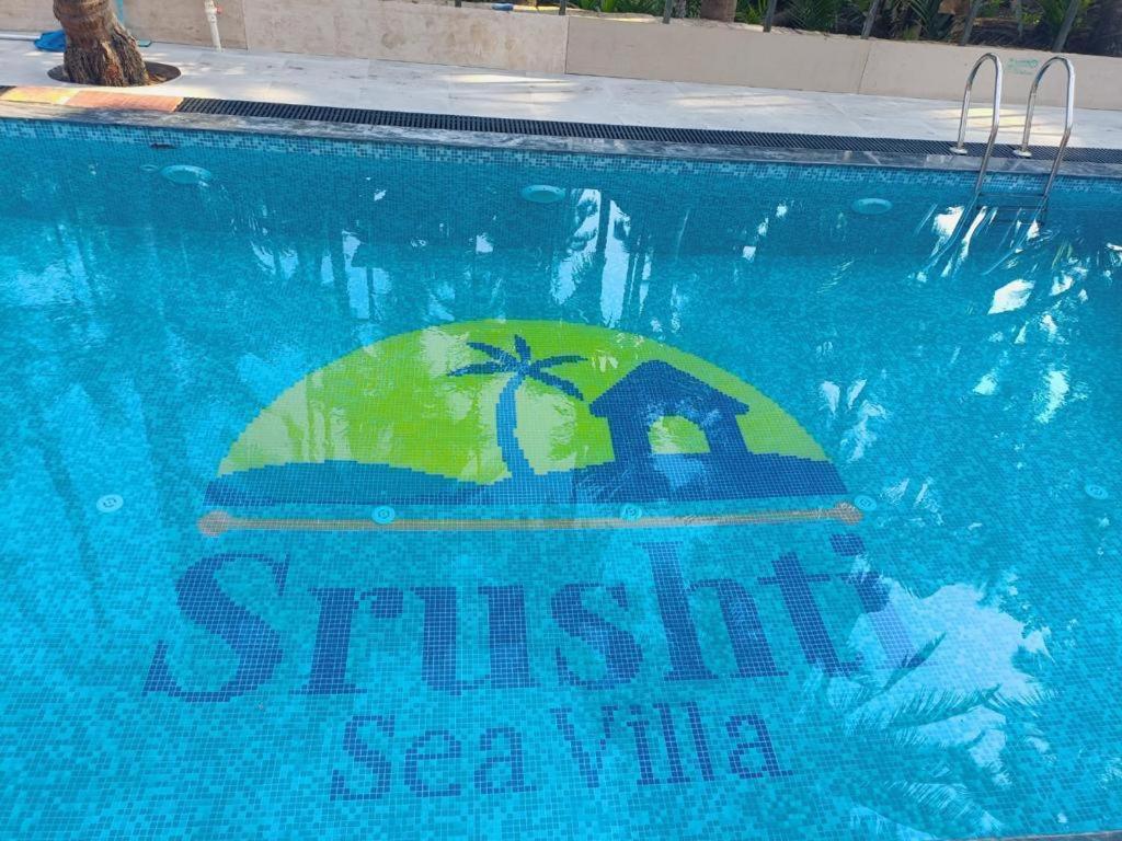 una piscina con un cartel que dice villa shushi en Srushti Sea Villa Resort, en Diveagar