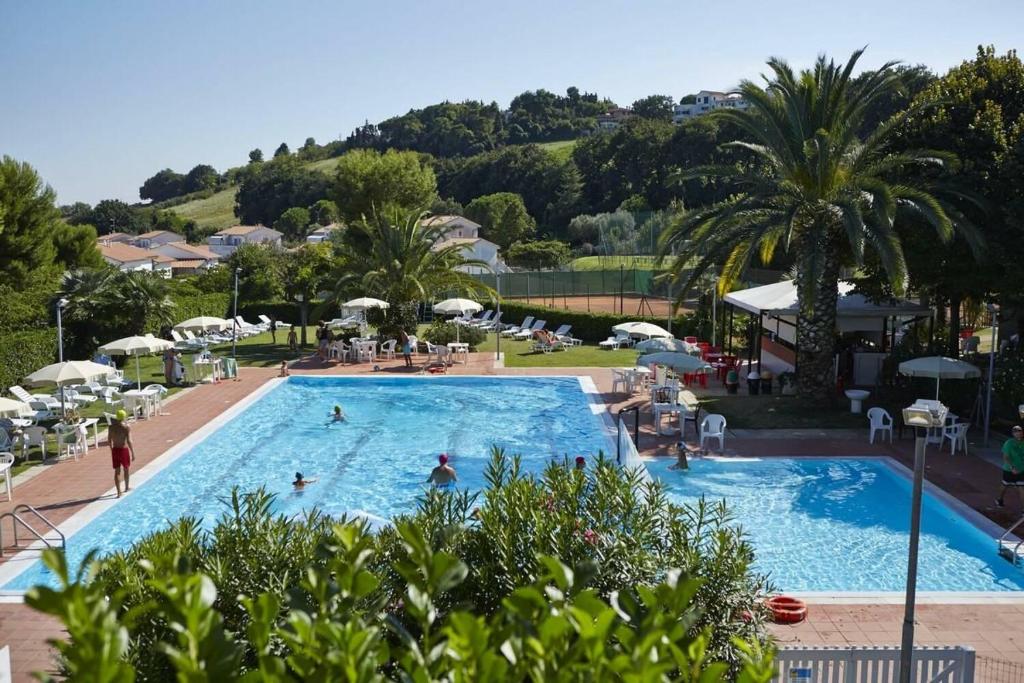 una grande piscina con persone in un resort di Villa Margherita Bilocale - Taunus Vacanze a Numana