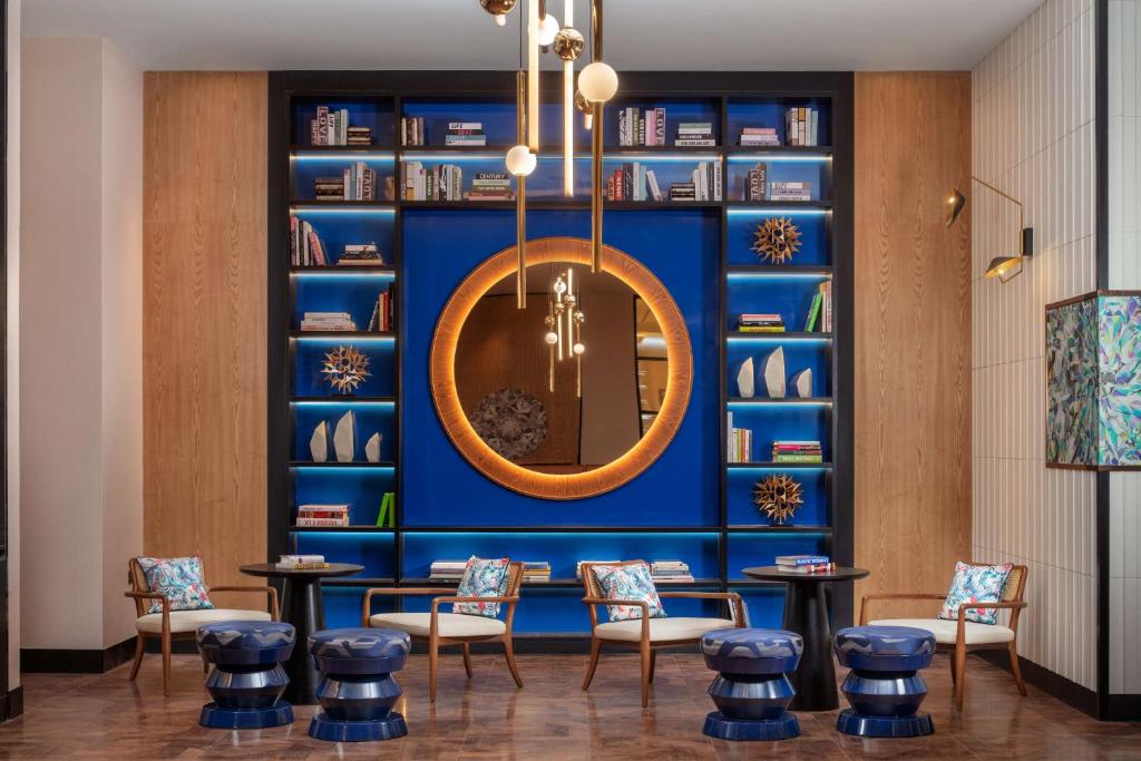 um quarto com uma parede azul, cadeiras e um espelho em Andaz Doha, A Concept by Hyatt em Doha