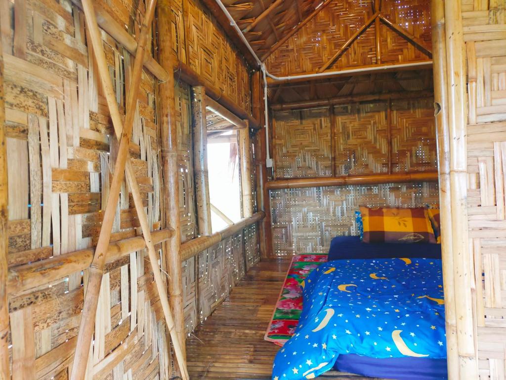 Habitación con cama en una cabaña de madera en บ้านควนคาเฟ่&โฮมสเตย์ สตูล, 