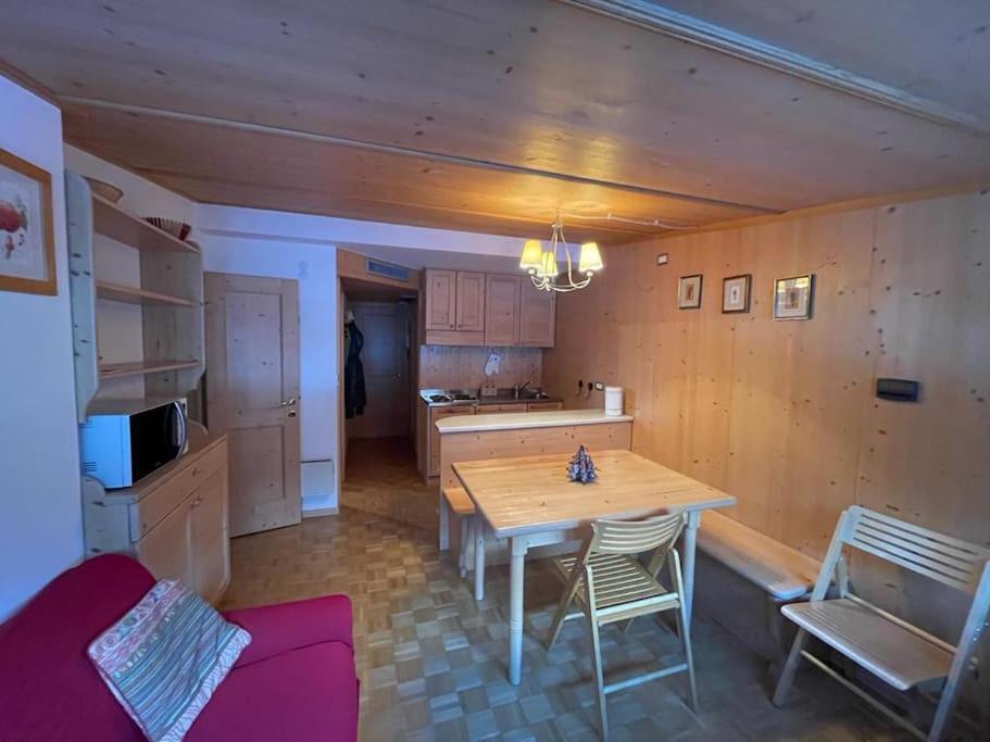 uma cozinha com mesa e cadeiras num quarto em Appartamento con vista sulle Pale di San Martino em San Martino di Castrozza