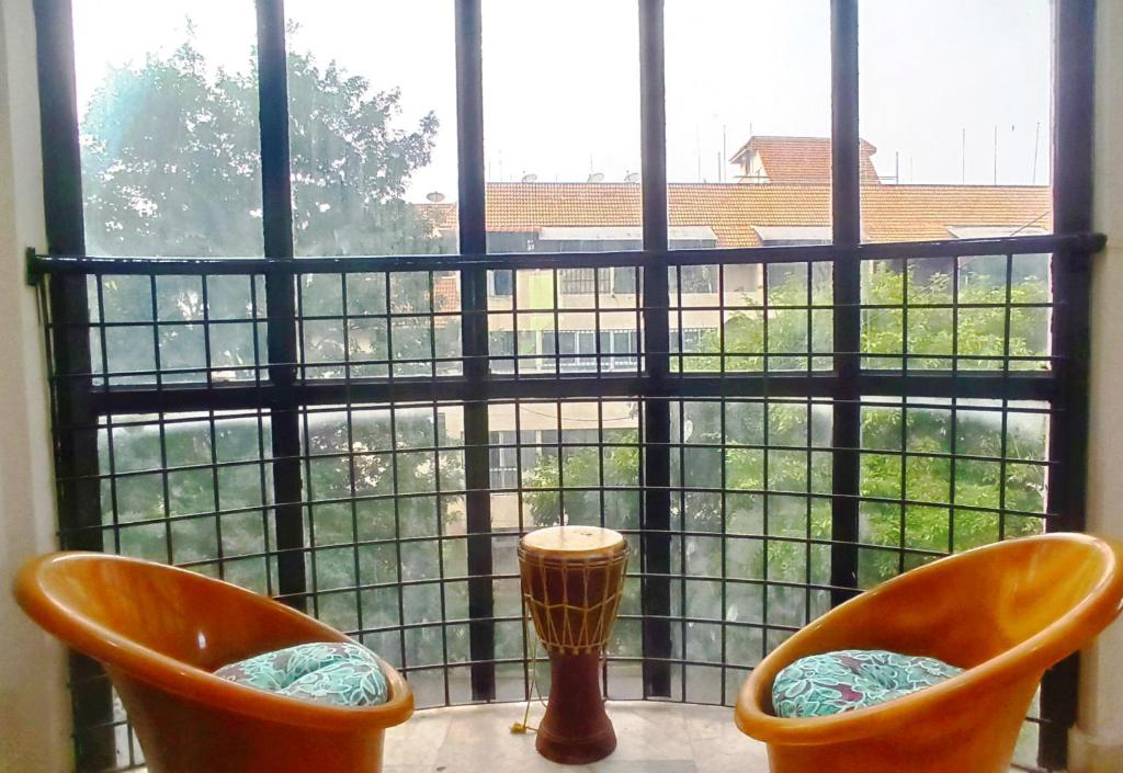 two orange chairs sitting in front of a window at Funky Buddha Hostel in Mysore