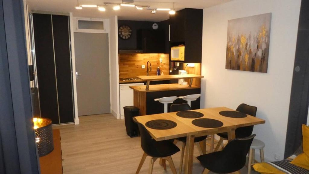 une cuisine avec une table et des chaises dans une pièce dans l'établissement BEL APPARTEMENT RENOVE 6 PERSONNES, 1 CHAMBRE ET GARAGE, au Grau-du-Roi
