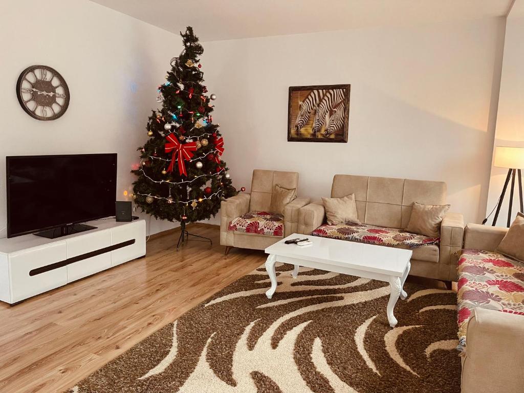 a living room with a christmas tree and a television at Fron's Apartment in Pristina