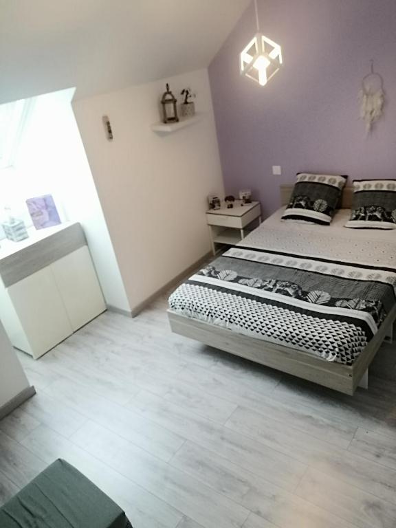 1 dormitorio con 1 cama grande en una habitación en Location 24H Le Mans, en Marigné-Laillé