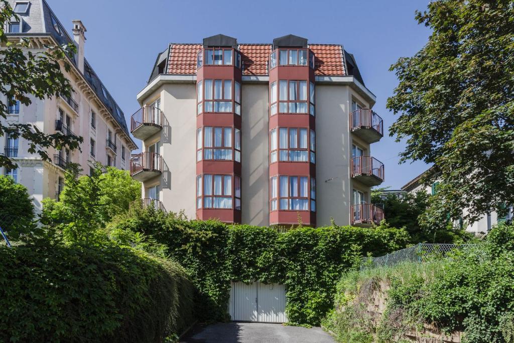 ein großes Apartmenthaus mit Efeu in der Unterkunft VISIONAPARTMENTS Chemin des Epinettes - contactless check-in in Lausanne