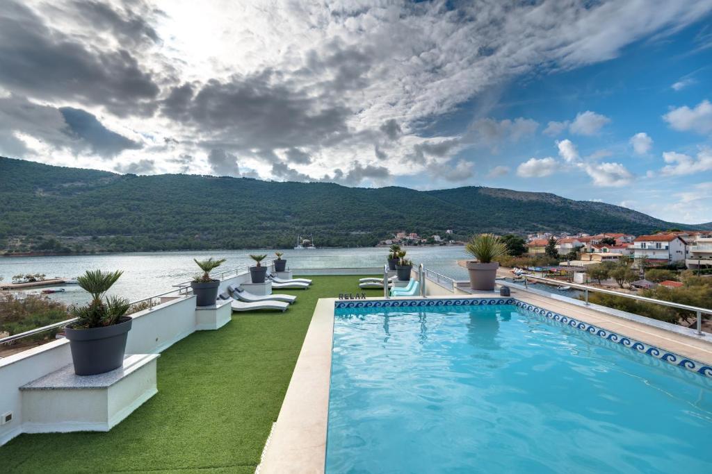 a pool on the roof of a building with a view of the water at Apartments Holidays Roko in Grebaštica