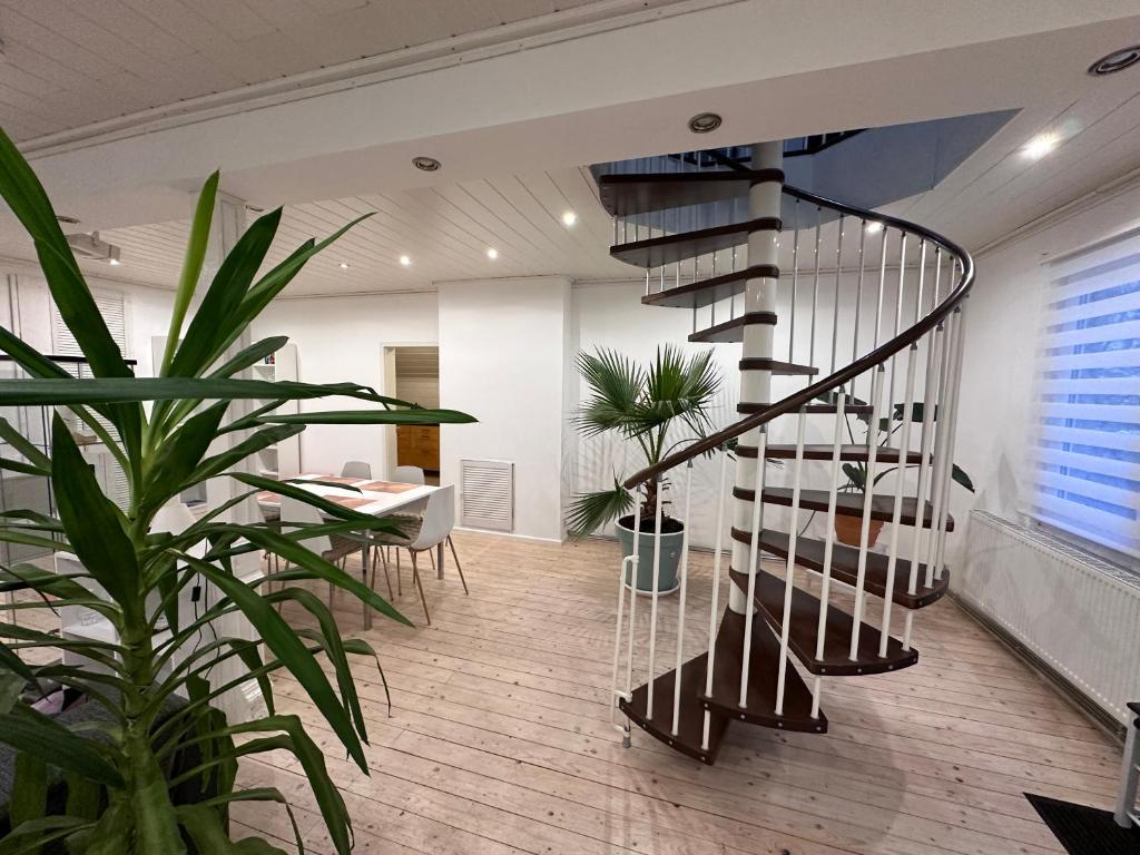 a spiral staircase in a room with a table and plants at Gästehaus pack of patches in Jena
