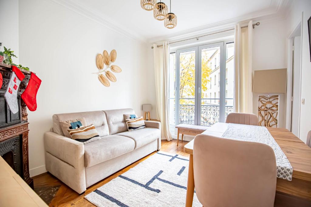een woonkamer met een bank en een tafel bij Paris naturellement in Parijs
