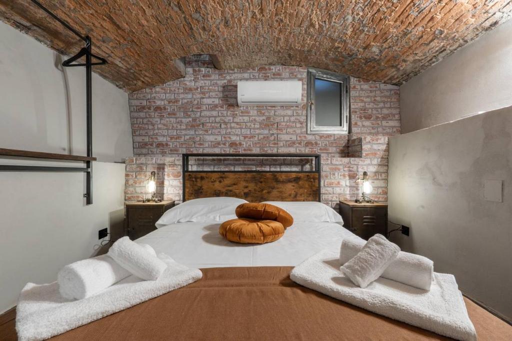 a bedroom with a large bed with a brick wall at Urban Loft in Florence