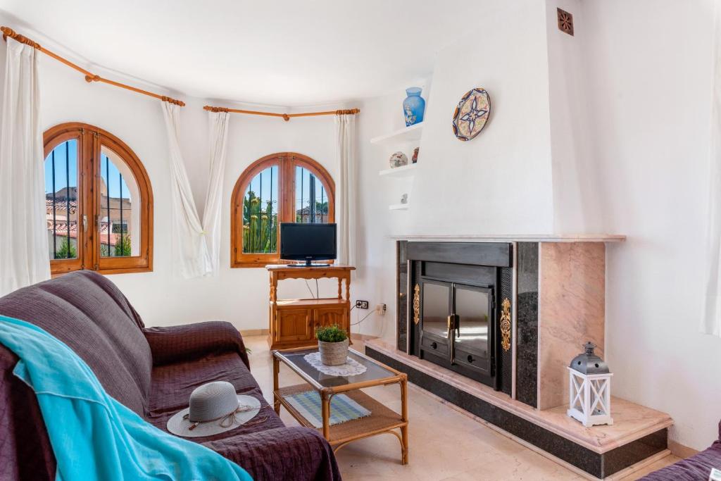 ein Wohnzimmer mit einem Kamin und einem Sofa in der Unterkunft Villa Cruz - PlusHolidays in Calpe