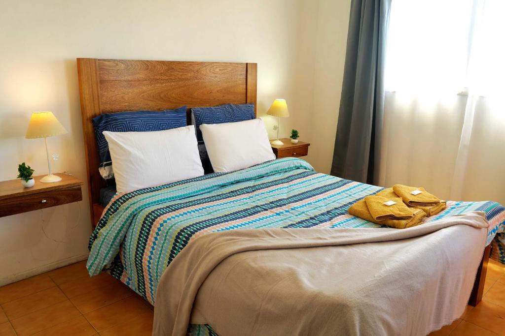 una camera da letto con un grande letto con lenzuola blu e bianche di Rent for Days - Microcentro a San Miguel de Tucumán