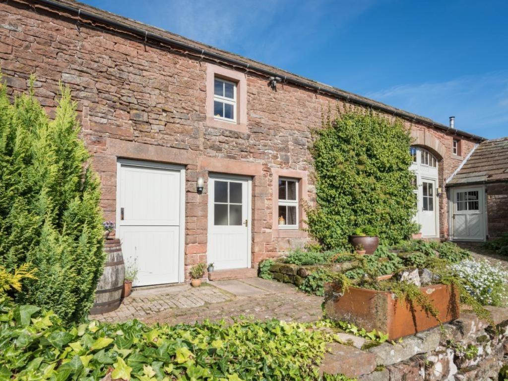 a brick house with two white garage doors at 2 Bed in Eden Valley SZ209 in Kirkoswald