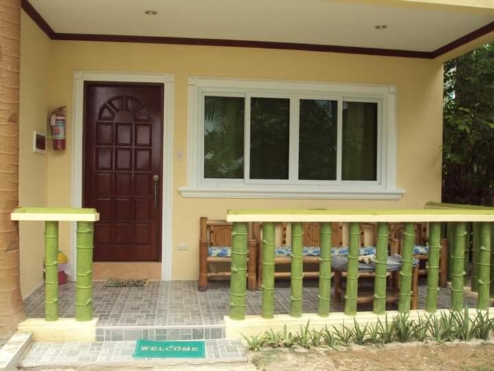 a house with a front porch and a door at HMC Guesthouse - Malapascua Island Air-conditioned Room #2 in Logon
