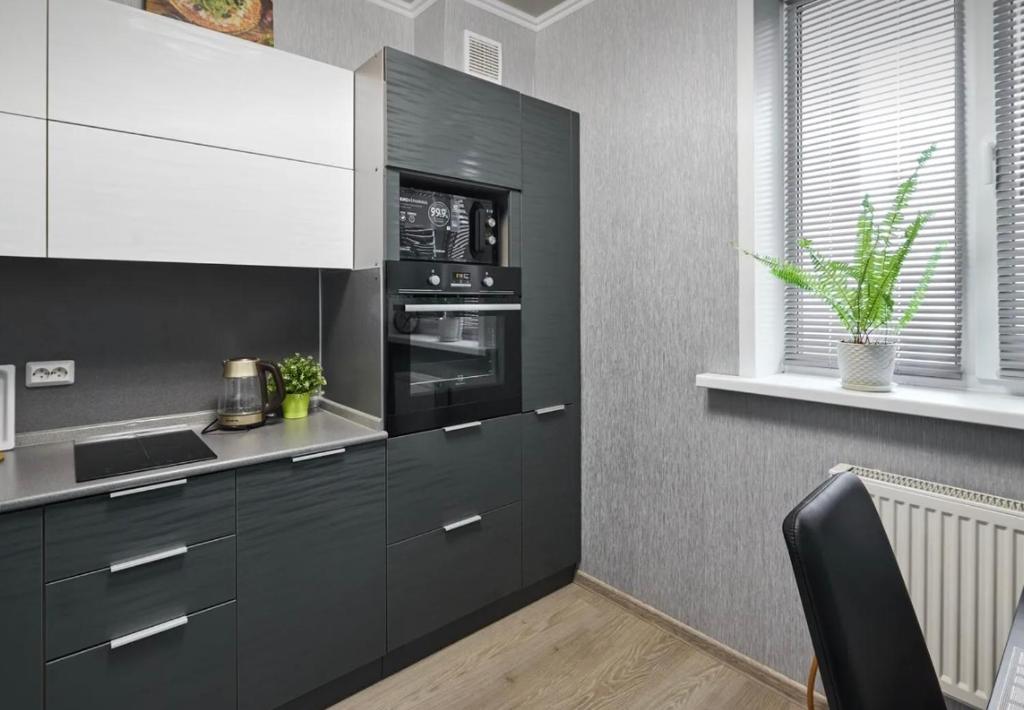 a kitchen with black cabinets and a microwave at VIP apart 703 in Tbilisi City