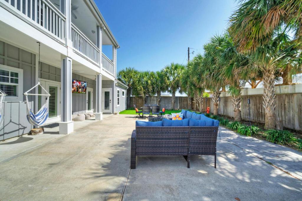 a bench in front of a house with palm trees at 16 Palms by AvantStay Luxury Pool Playscape in Port Aransas