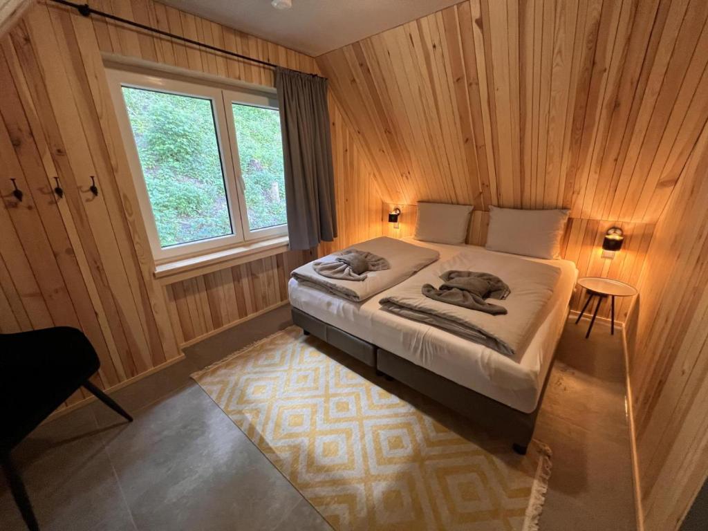 維林根的住宿－Haus Bergquell App 6，卧室配有木墙内的一张床