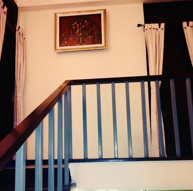 a staircase with a painting on the wall and a stair case at Raichak Ak22 Homestay in Raichak