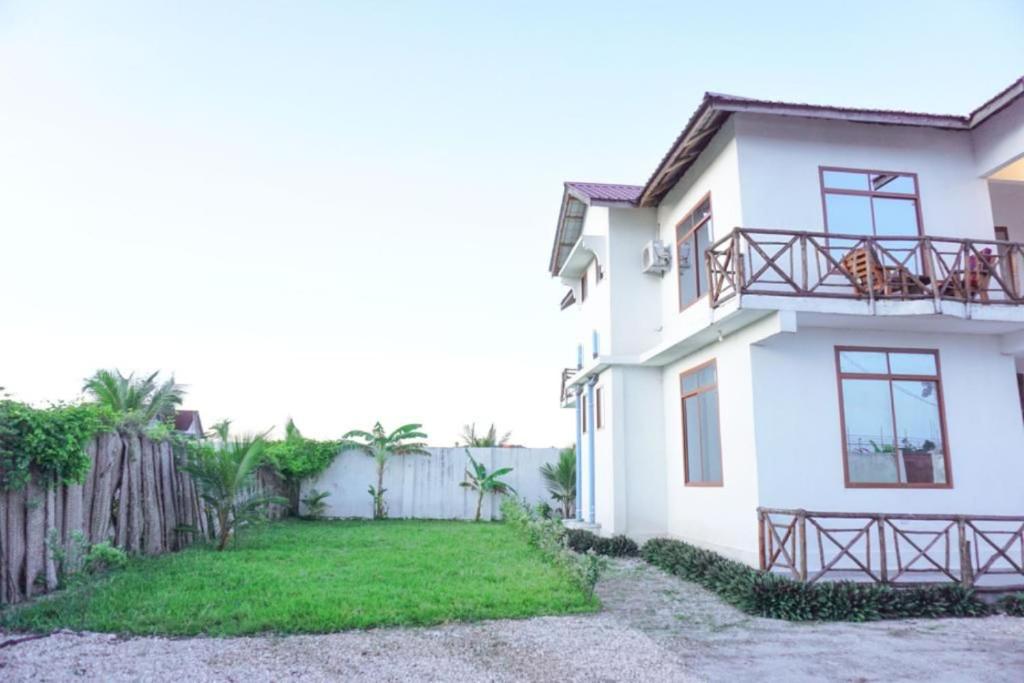 una casa blanca con una valla y un patio en Asili Nyumbani Residence en Kiwengwa