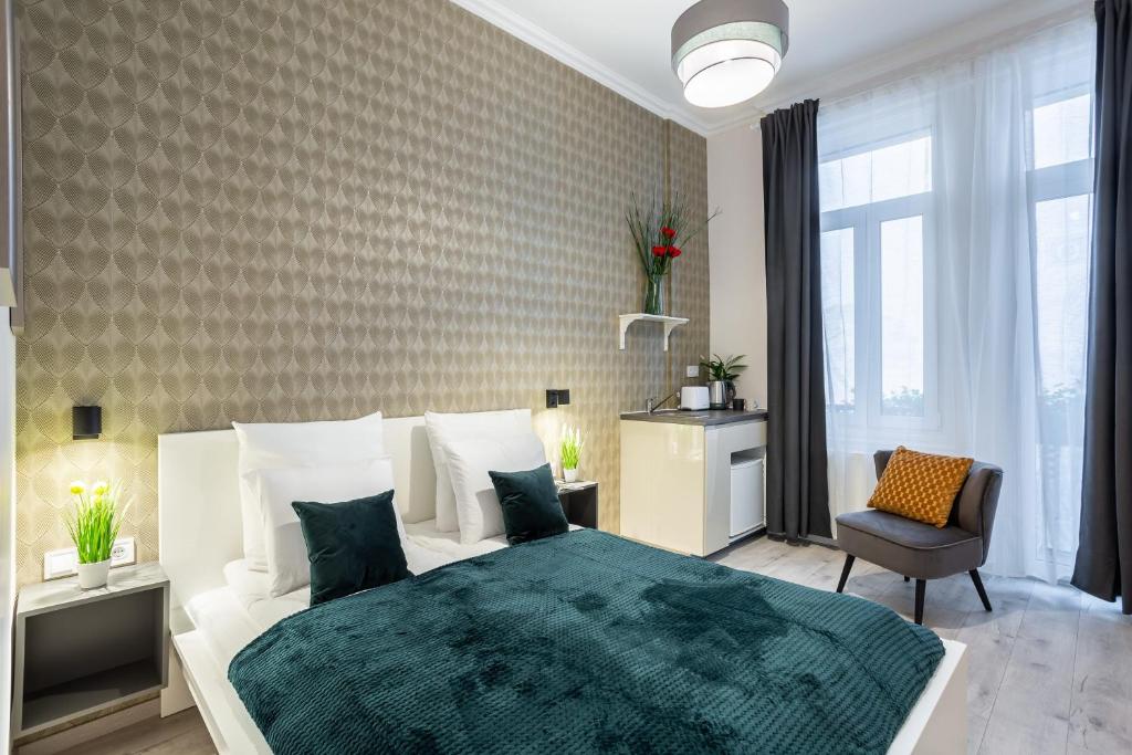 a bedroom with a white bed with a green blanket at Extra Central New & Stylish Studio in Budapest