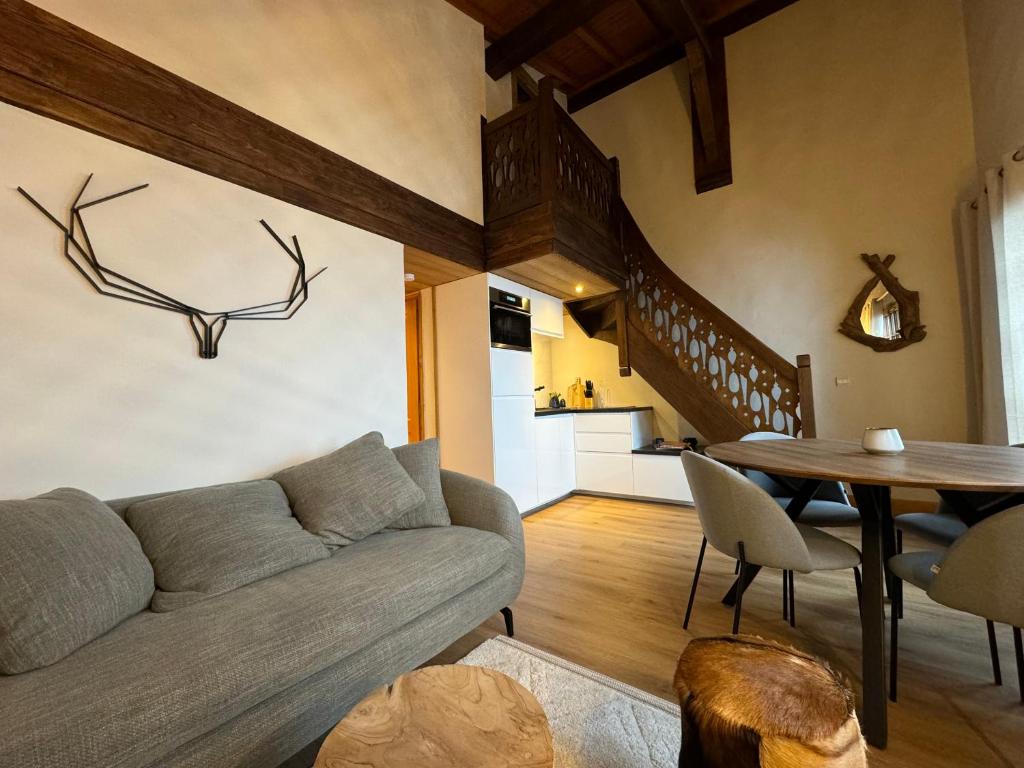 a living room with a couch and a table at CHALET LE REPAIRE PROCHE PISTE in Megève