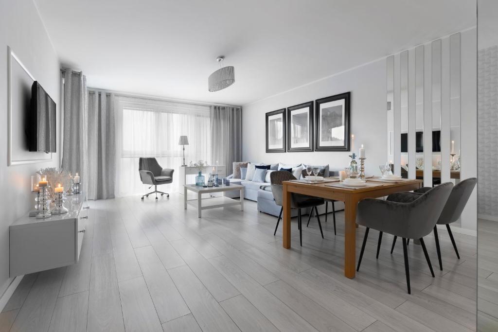 uma sala de estar e de jantar com mesa e cadeiras em Elite Apartments Downtown Premium em Gdansk