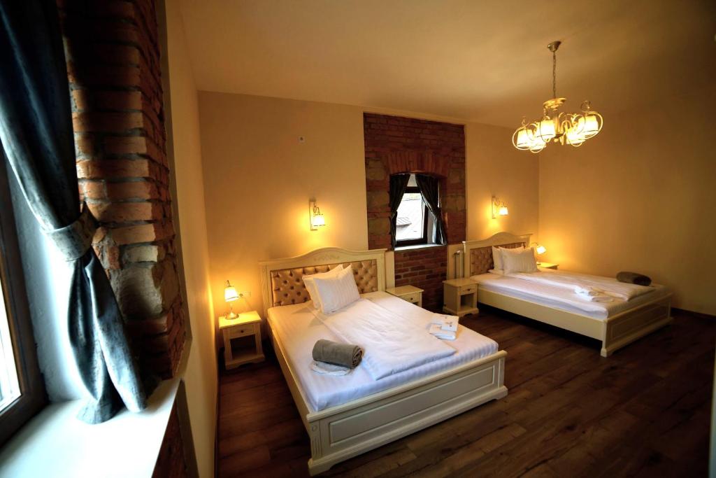 een slaapkamer met 2 bedden en een kroonluchter bij Casa Huber in Sighetu Marmaţiei