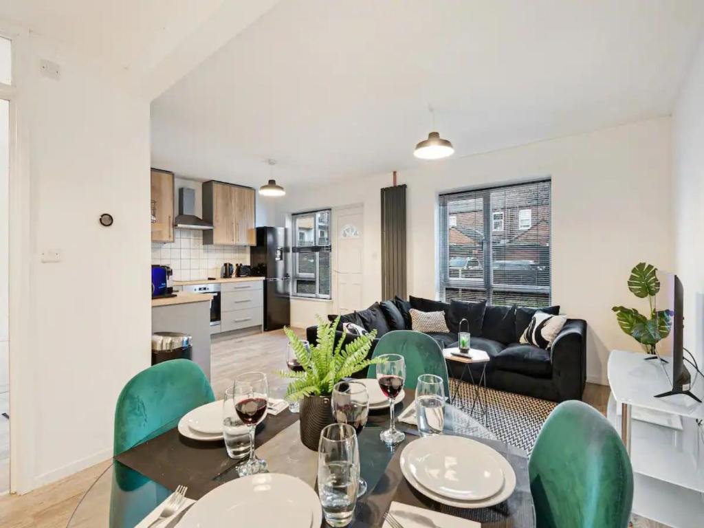 a kitchen and living room with a table and chairs at Pass the Keys 3 bedroom modern house in Withington in Manchester