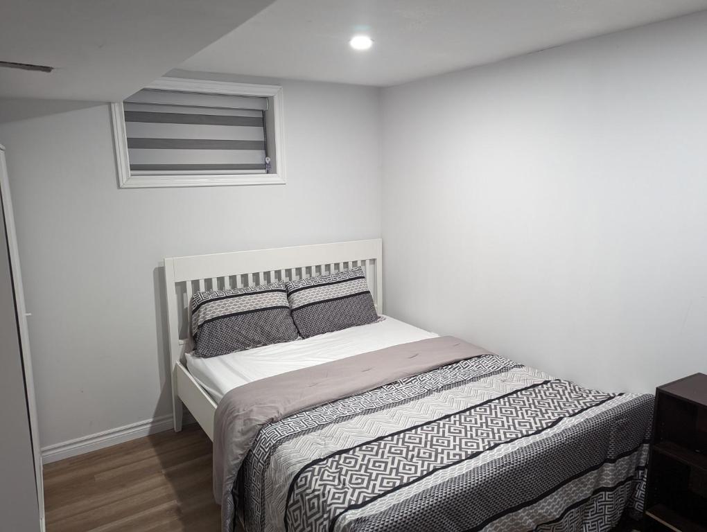 um quarto branco com uma cama com 2 almofadas em House of Pleasantness em Hamilton