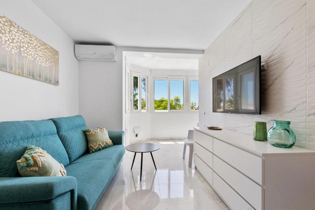 a living room with a blue couch and a tv at Espanatour MENORCA in Dehesa de Campoamor