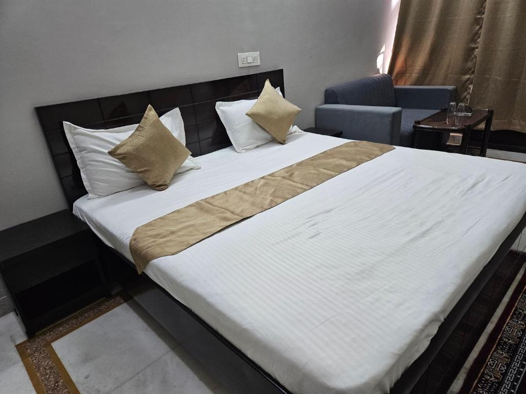 a bedroom with a large bed with white sheets and pillows at RAJ RESIDENCY in Gurgaon