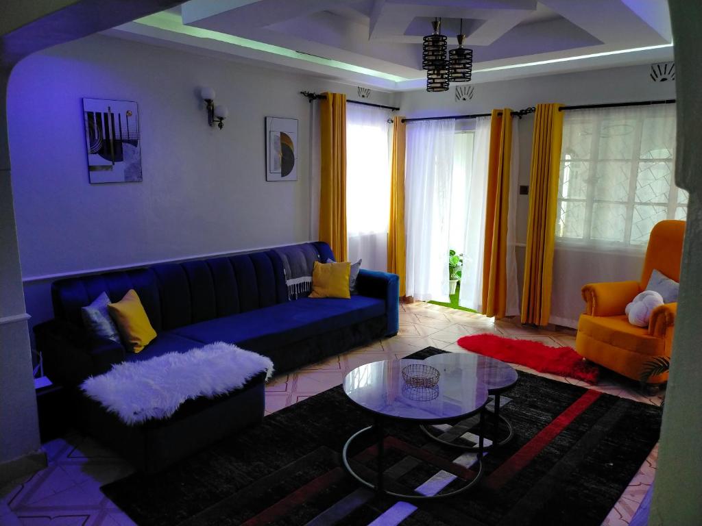 a living room with a blue couch and a table at Greenstar Homes in Kisii