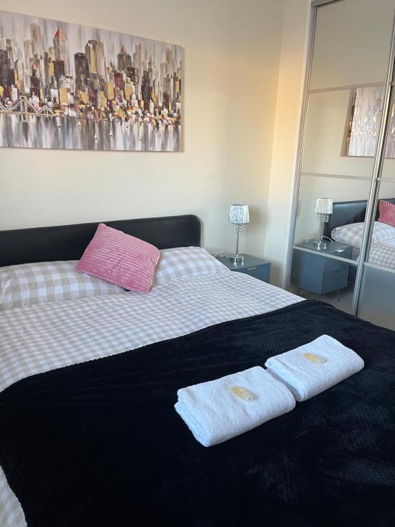 a bedroom with a bed with two towels on it at beautiful 2 bedrooms flat for family in Portsmouth