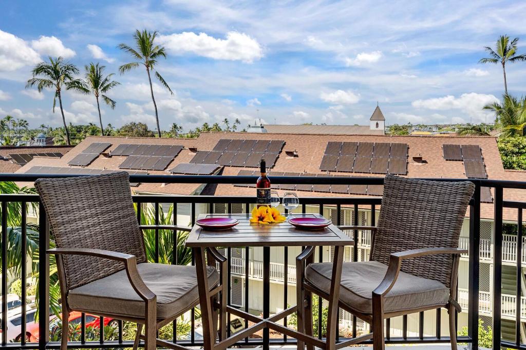 a table and chairs on a balcony with solar panels at Kona Alii 512 in Kailua-Kona