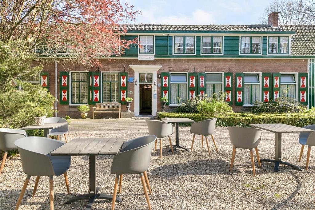 a group of tables and chairs in front of a building at Hotel Randduin in Oostkapelle
