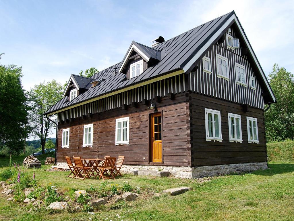 a large wooden house with a black roof at Chalet Sluneční vršek by Interhome in Horní Polubný