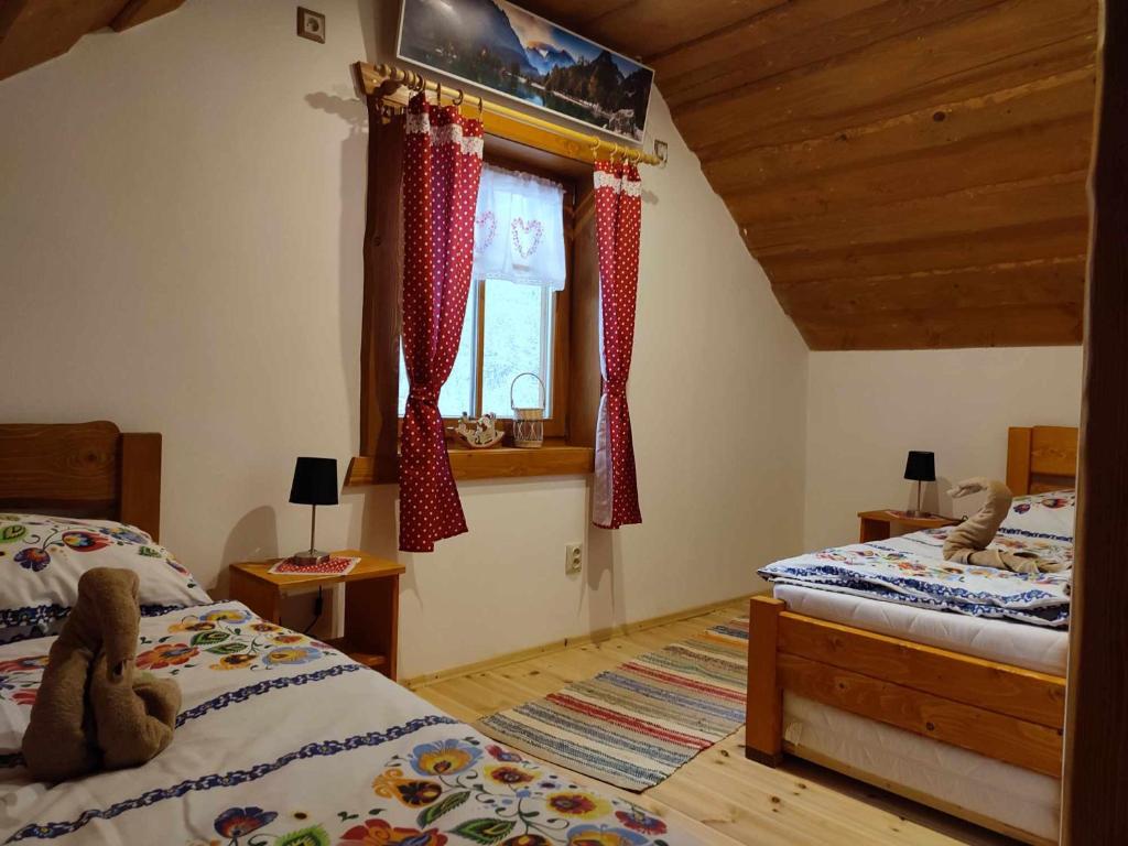 a bedroom with two beds and a window at Dolná chata u Bratríkov in Haligovce