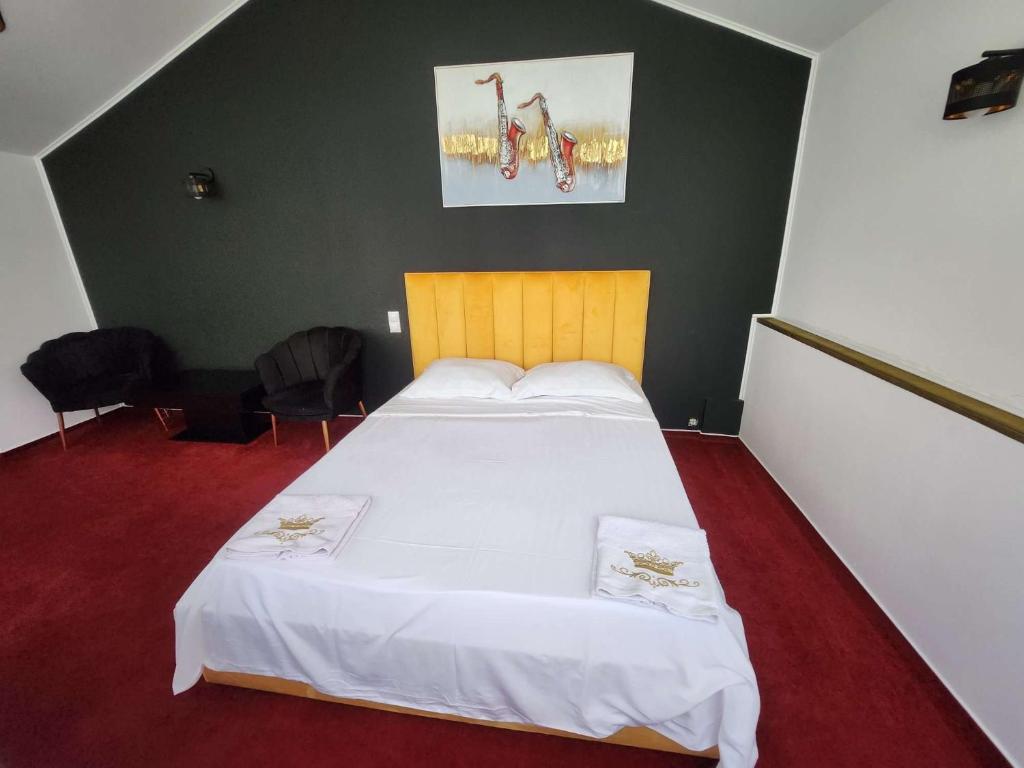 - une chambre avec un grand lit et des draps blancs dans l'établissement Karma caffe&rooms, à Bucarest