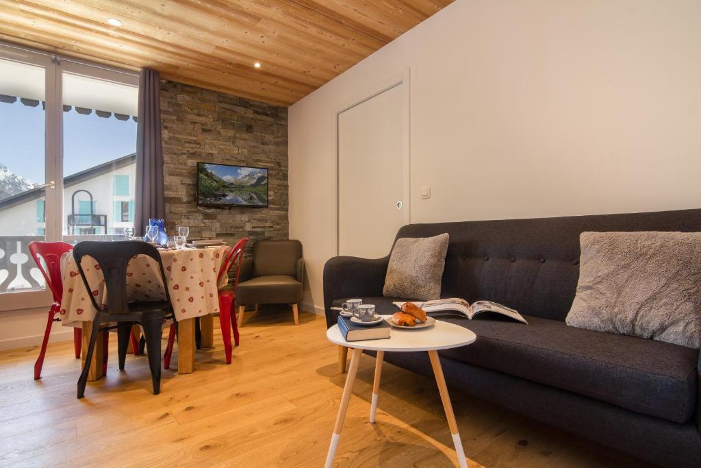 ein Wohnzimmer mit einem Sofa und einem Tisch in der Unterkunft Chamonix Sud - Chailloud 202 - Happy Rentals in Chamonix-Mont-Blanc