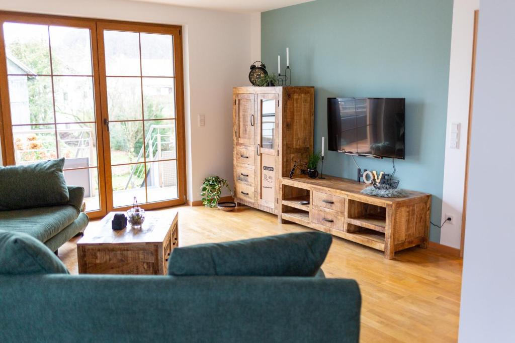 a living room with two couches and a flat screen tv at Haus Martina in Poppenhausen