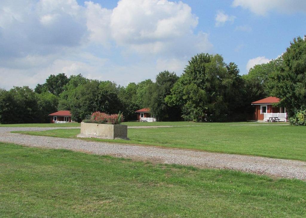 a gravel path in a park with two buildings at Spindlewood Lodges in North Wootton