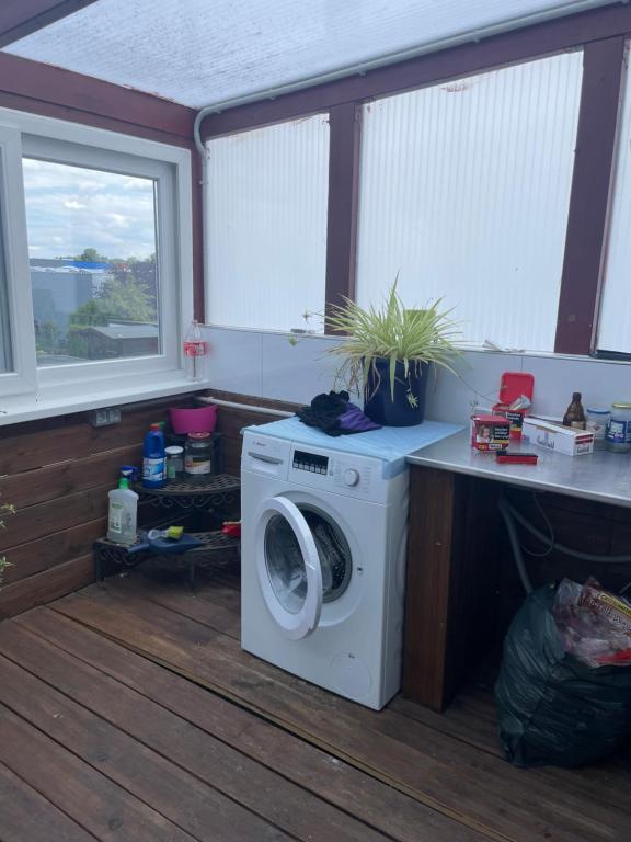 eine Waschmaschine und einen Trockner in einem Zimmer mit Fenstern in der Unterkunft Zimmer in Ein Haus mit Waschmaschine in Mönchengladbach