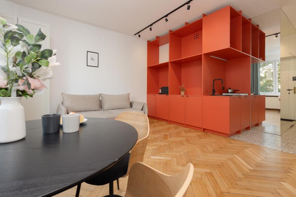 ein Wohnzimmer mit einem Tisch und einem Sofa in der Unterkunft Comfortable and Modern Orange Studio in Warsaw by Renters in Warschau