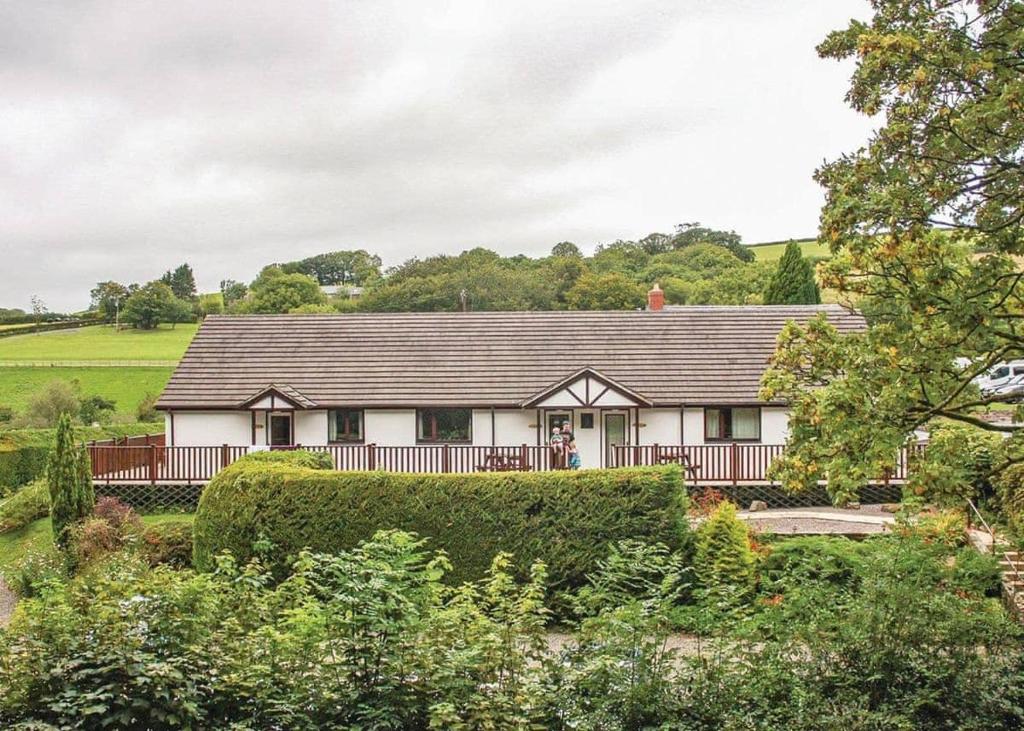 a white house with a black roof at Avalon Cottages in Llangynin