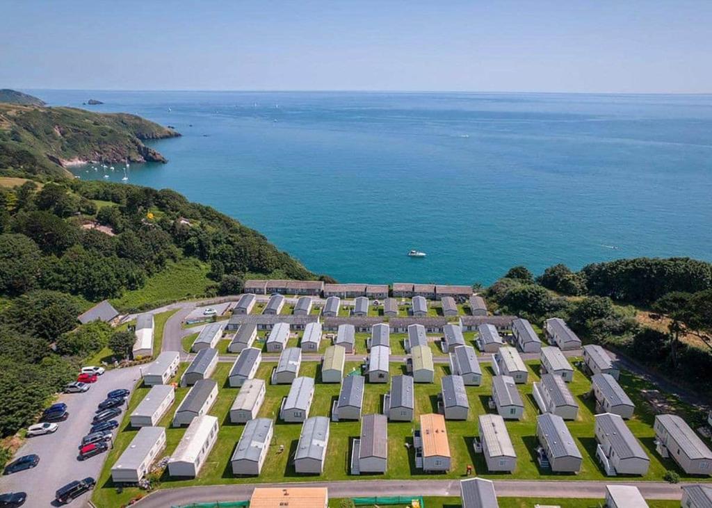 an aerial view of a building with the ocean in the background at Leonards Cove in Stoke Fleming