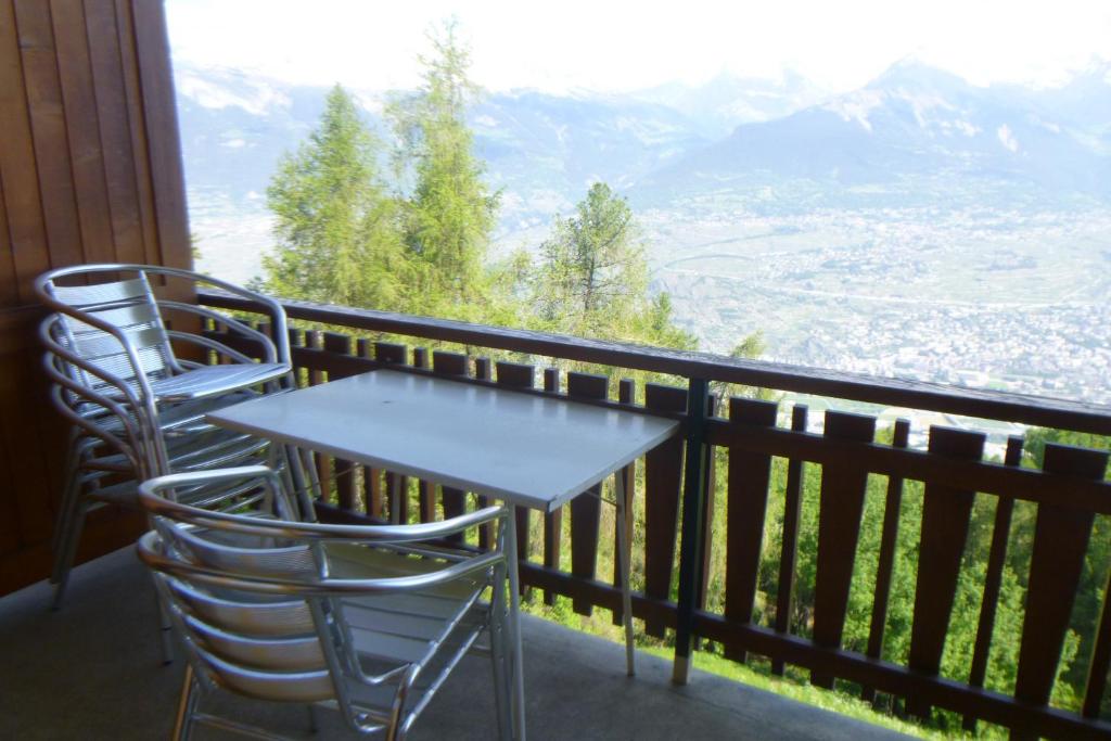 een tafel en stoelen op een balkon met uitzicht bij Bellevue L 031 - PLEASANT apartment 6 pers in Veysonnaz