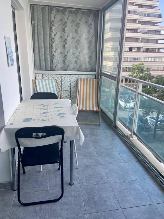 Cette chambre dispose d'un balcon avec une table et des chaises. dans l'établissement BEL APPARTEMENT P2 - CENTRE VILLE - BORD DE MER, à La Grande Motte